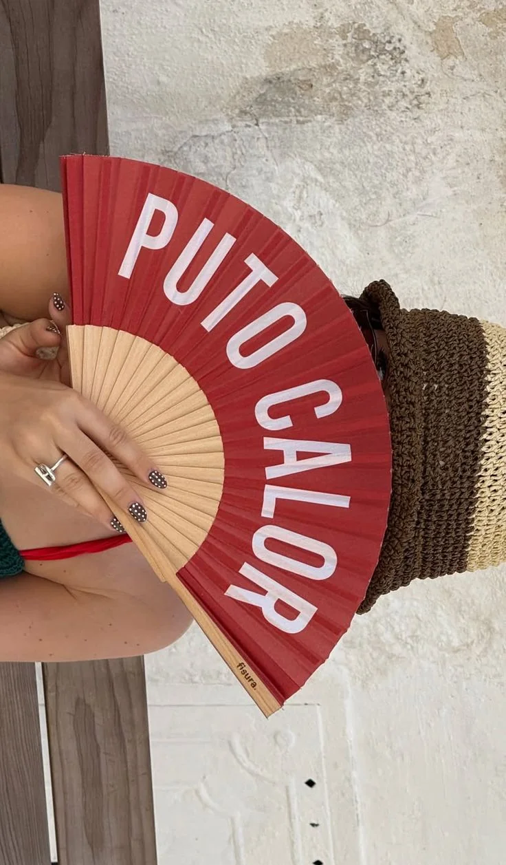 Abanico rojo personalizado con letras blancas, sostenido en la mano
