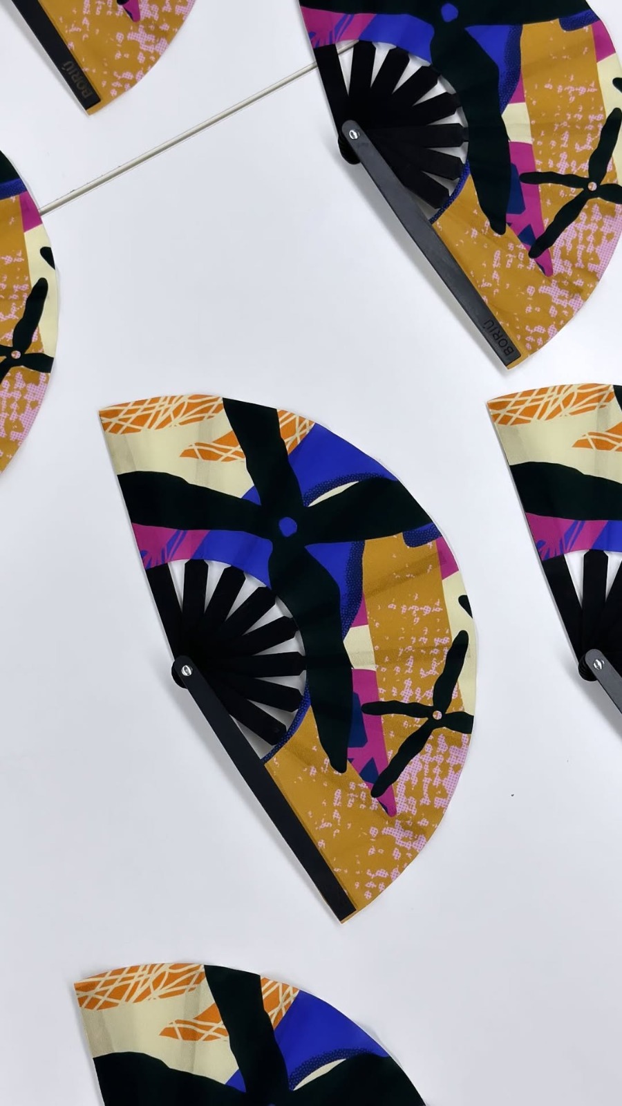 Abanicos personalizados con estampado geométrico a color para la marca Boriu, usados en activaciones de calle